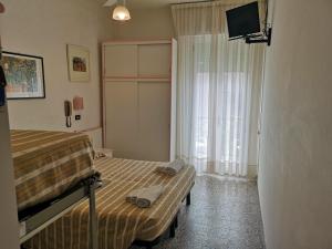 a bedroom with two beds and a tv and a window at Hotel Rosy in Rimini +66 photos