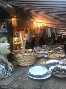 una línea de buffet con platos de comida en una mesa en Casa Gisira, en Catania