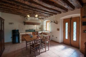a large kitchen with a wooden table and chairs at La Cascina d'Orleans in Saint-Pierre +23 photos