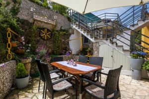 a table and chairs on a patio with stairs at Apartments and rooms Roberto B. in Valun