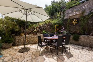 a table and chairs with an umbrella on a patio at Apartments and rooms Roberto B. in Valun