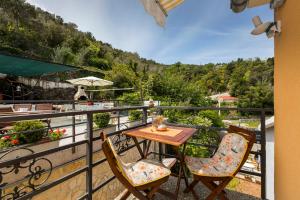 a table and chairs on a balcony with a view at Apartments and rooms Roberto B. in Valun