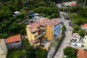an overhead view of a yellow house with red roof at Apartments and rooms Roberto B. in Valun