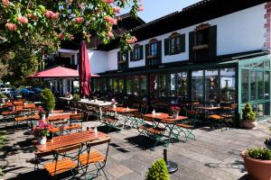 a patio with tables and chairs in front of a building at Gästehaus Rössler in Brannenburg