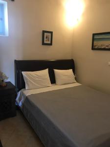 a bedroom with a bed with white pillows at Katsinaros House in Emporio