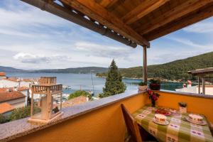 a balcony with a table and a view of the water at Apartments and rooms Roberto B. in Valun