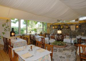 a restaurant with white tables and chairs and windows at Auberge de Dully in Dully