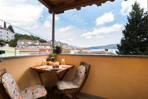 a table and chairs on a balcony with a view at Apartments and rooms Roberto B. in Valun