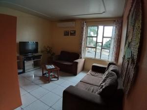 a living room with a couch and a tv at Hotel Pousada Sinos in São Leopoldo