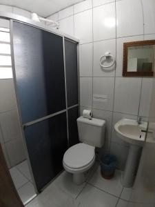 y baño con ducha, aseo y lavamanos. en Hotel Pousada Sinos en São Leopoldo