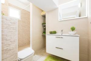 a bathroom with a toilet and a sink at Apartments and rooms Roberto B. in Valun