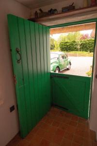 a green door with a car in a parking lot at Rosehill House in Dungannon