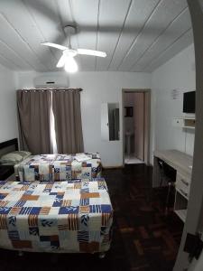 a hotel room with two beds and a desk at Hotel Pousada Sinos in São Leopoldo