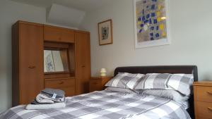 a bedroom with a bed and a dresser at The Apartment Bushmills in Bushmills