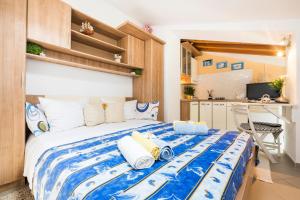 a bedroom with a large bed with blue and white sheets at Apartments and rooms Roberto B. in Valun