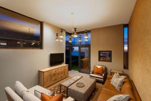 a living room with a couch and a tv at Alkira Lodge in Brenton-on-Sea