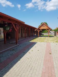 a building with a brick walkway and a pavilion at Tisza-Tavirózsa Vendégház in Tiszaszőlős