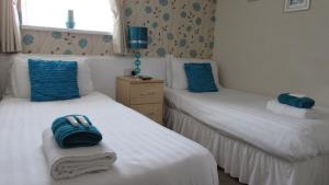 
a hotel room with two beds and two lamps at Bamford House Hotel in Blackpool
