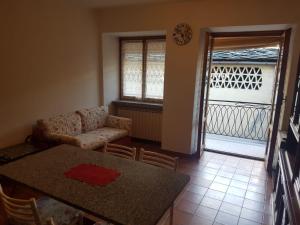 a living room with a table and a couch at Casa Cippilippi in Saint Vincent