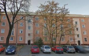 a large brick building with cars parked in a parking lot at Győri úti lakás in Tatabánya