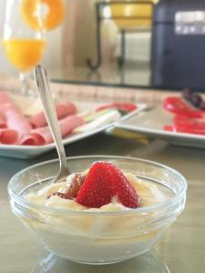 a bowl of dessert with a strawberry and a spoon at Dimitris Villa Hotel in Matala