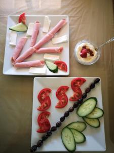 two plates filled with different types of cheese and vegetables at Dimitris Villa Hotel in Matala