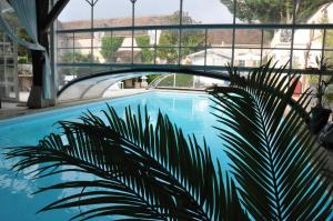 a bridge over a swimming pool with a plant at La Bergerie des Anges in Le Bignon-Mirabeau