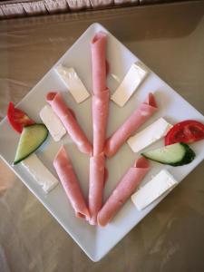 a plate of food with meat and cheese and fruit at Dimitris Villa Hotel in Matala