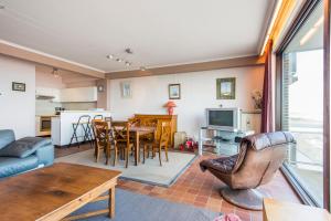 ein Wohnzimmer und eine Küche mit einem Tisch und Stühlen in der Unterkunft Ascot 5de in Zeebrugge