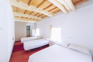 a bedroom with two beds and a couch at Monkey Fingers House by Fatima mellal in Tinerhir