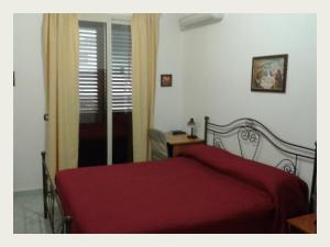 ポッツァッロにあるB&B Alloggi Buonaseraのベッドルーム1室(赤い毛布付きのベッド1台付)