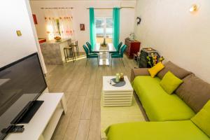 sala de estar con sofá verde y TV en Apartments Andrea en Baška