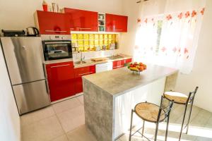 a kitchen with red cabinets and a bowl of fruit on the counter at Apartments Andrea in Baška