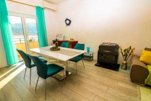 a living room with a table and chairs and a fireplace at Apartments Andrea in Baška