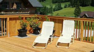 two white lawn chairs sitting on a deck at Familien & Wander-Pension Purkhardt in Donnersbachwald +71 photos