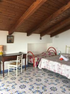 um quarto com uma secretária e uma cama em Balconcino degli innamorati Tropea em Santa Domenica