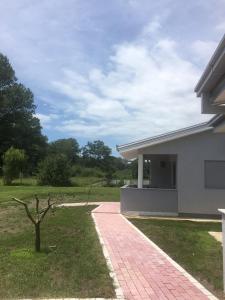 a house with a brick walkway in front of a yard at Helena's Sweet Home in Ulcinj