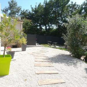 un jardín con una pasarela de piedra en un patio en appartements dans villa avec terrasse, jardin, parking clos, wifi, en Meyreuil