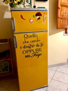 un frigorifero giallo con scrittura sul lato di Nonna Lelletta a Lanusei
