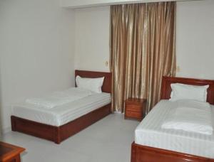 1 dormitorio con 2 camas y ventana en Al Sqlawi Hotel Apartments, en Sur