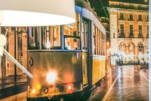 Un tranvía en una calle de la ciudad por la noche en HOME4U - Secret Studio in City Center, en Lisboa