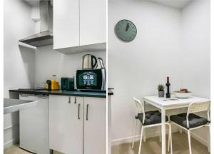 Una cocina con una mesa y un reloj en la pared. en HOME4U - Secret Studio in City Center, en Lisboa