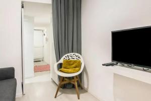een woonkamer met een witte stoel en een geel kussen bij HOME4U - Secret Studio in City Center in Lissabon