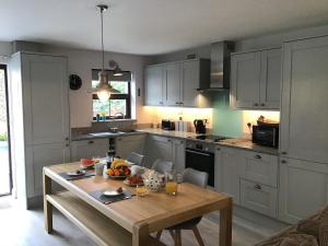 a kitchen with a table with a bowl of fruit on it at Sunnyside Cottage in Crantock