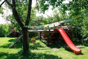 a playground with a red slide and a tree at Na Okić - a private forest oasis in Sveti Martin pod Okićem