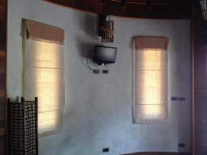 a living room with two windows and a tv at Malibu Beach Bungalows in Chaloklum