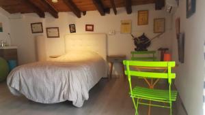 a bedroom with a bed and two green chairs at Habitación en Pozuelo de Alarcón in Pozuelo de Alarcón