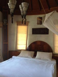 a bedroom with a bed with white sheets and a window at Malibu Beach Bungalows in Chaloklum +37 photos