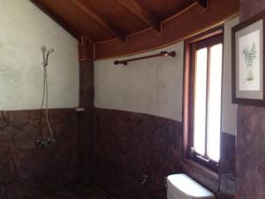 a bathroom with a shower and a toilet and a window at Malibu Beach Bungalows in Chaloklum
