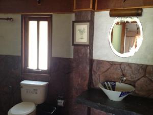 a bathroom with a toilet and a mirror at Malibu Beach Bungalows in Chaloklum
